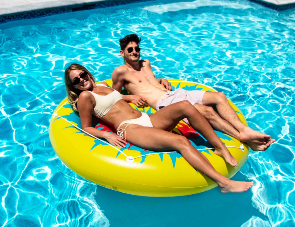 Two People On Swimline® Tie Dye Island Inflatable Pool Float