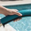 Pool Rail Cover by Rail Runners, Teal detail shot of someone's hand on the cover next to a pool