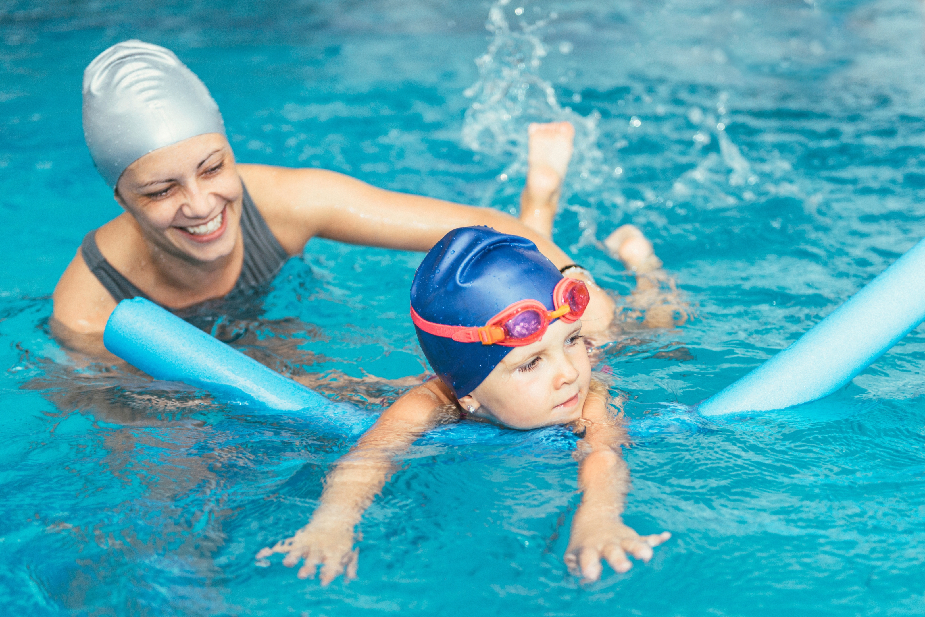 A woman and boy enjoying swimming together