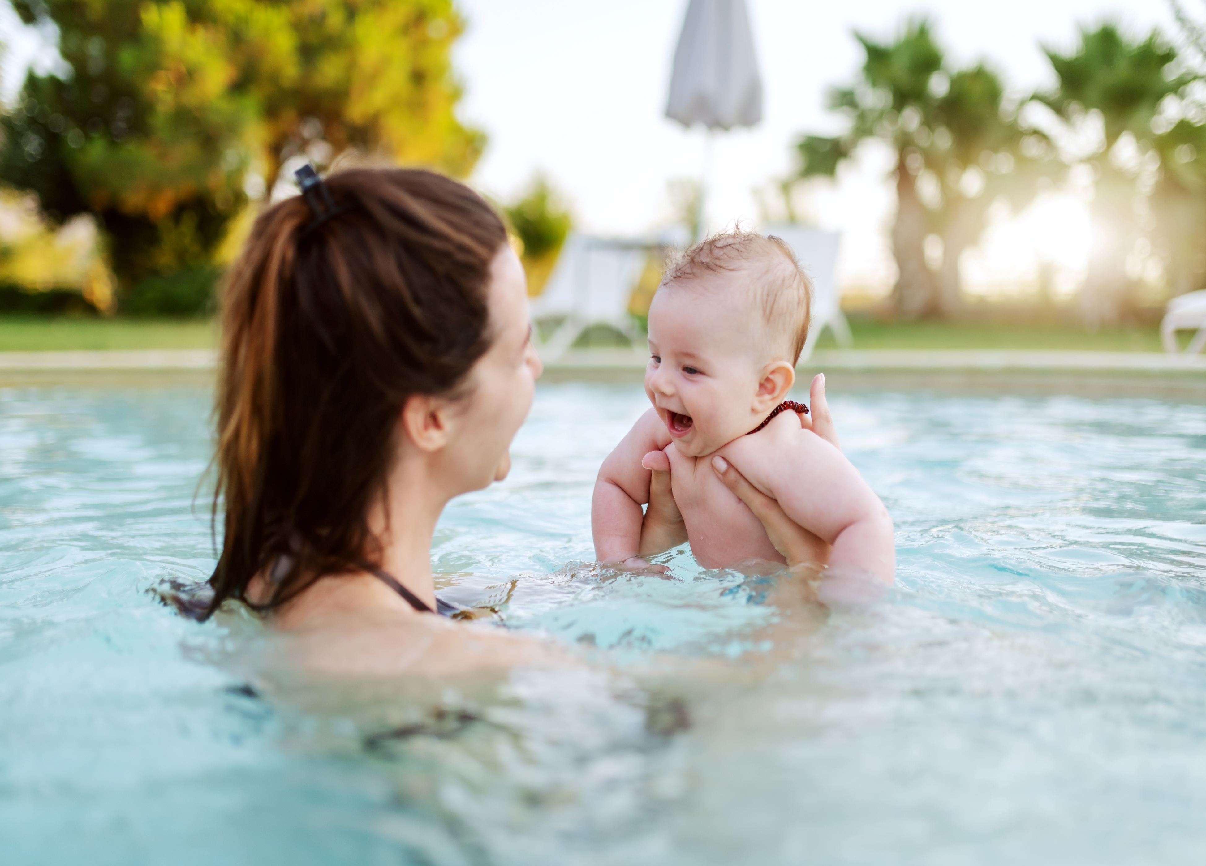 A mother and a baby in a pool