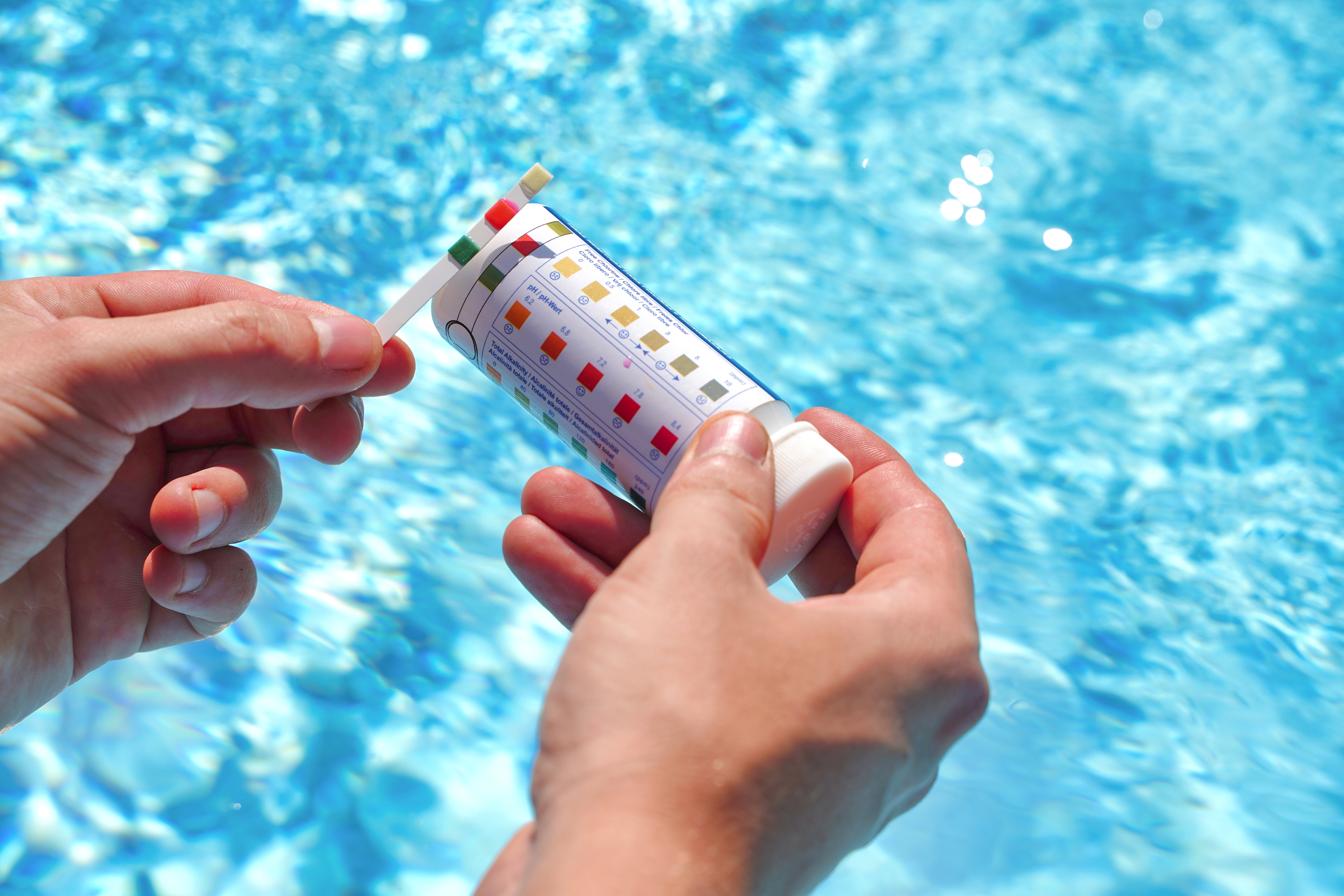 a person testing their pool with test strips