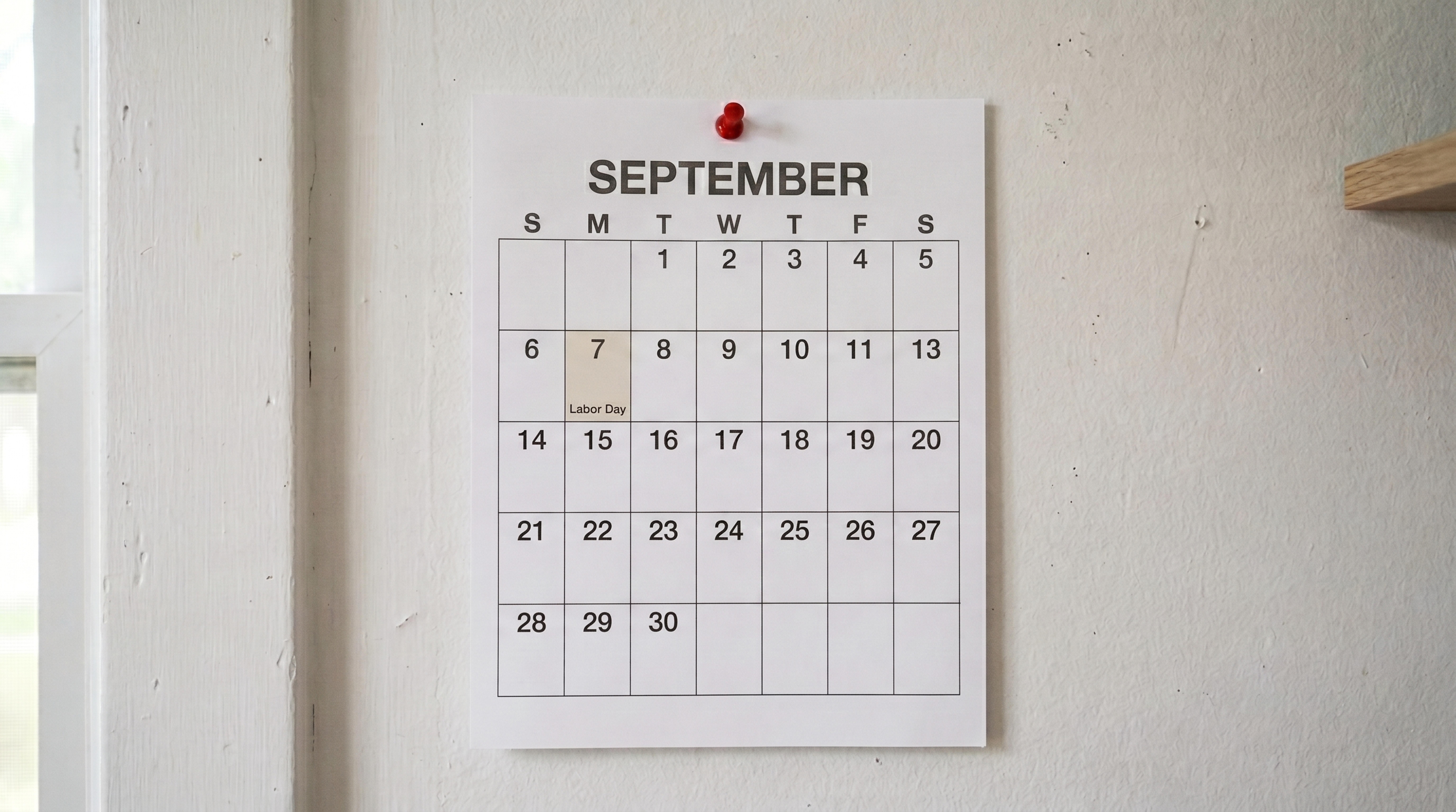 A wall calendar with labor day highlighted