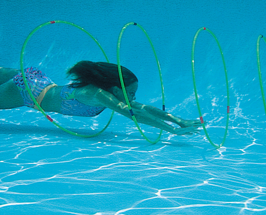 A woman swimming through underwater hoops